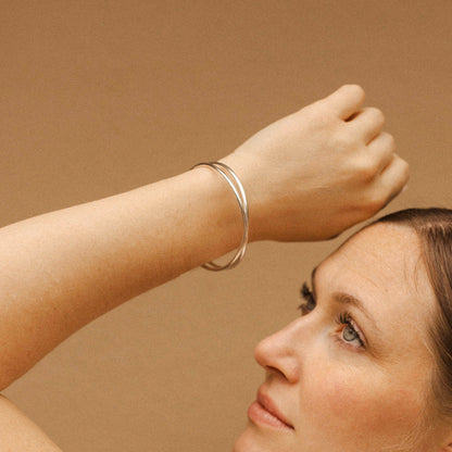 Woman wearing a silver bracelet on a beige background