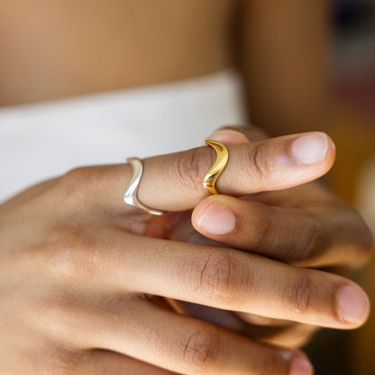 Close-up of a hand wearing two rings with a blurred background