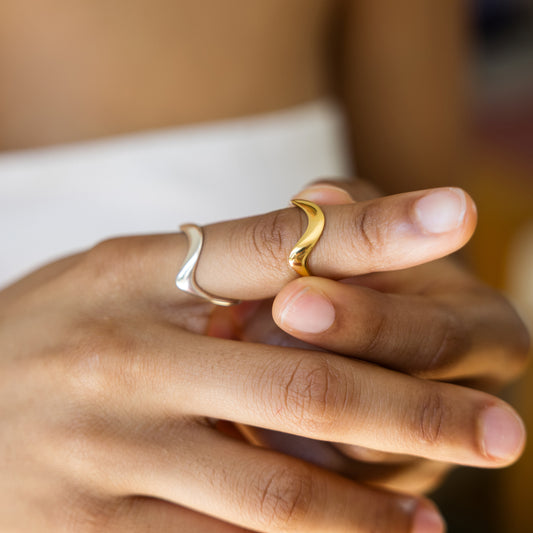 Close-up of a hand wearing two rings with a blurred background