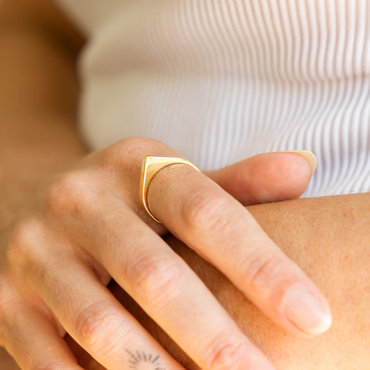 Gold ring on a finger with a blurred background