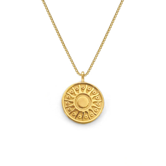 Gold necklace with a round pendant on a white background