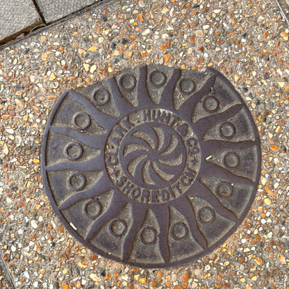 Decorative manhole cover on a textured pavement