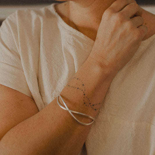 Person wearing a silver wave bangle bracelet