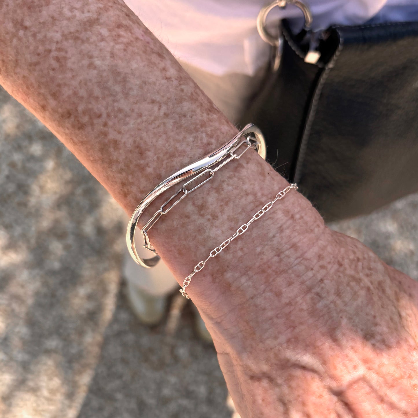 Silver bracelet on a wrist with a blurred background