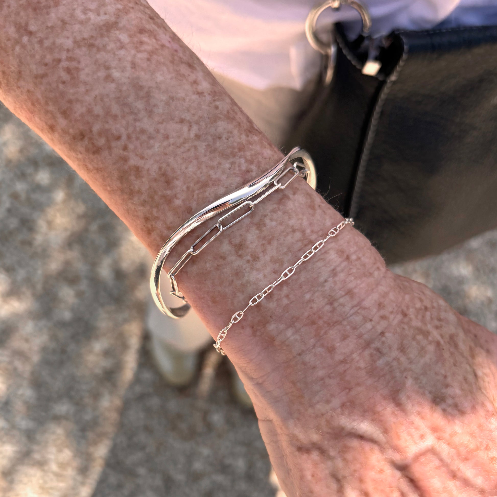 Silver bracelet on a wrist with a blurred background