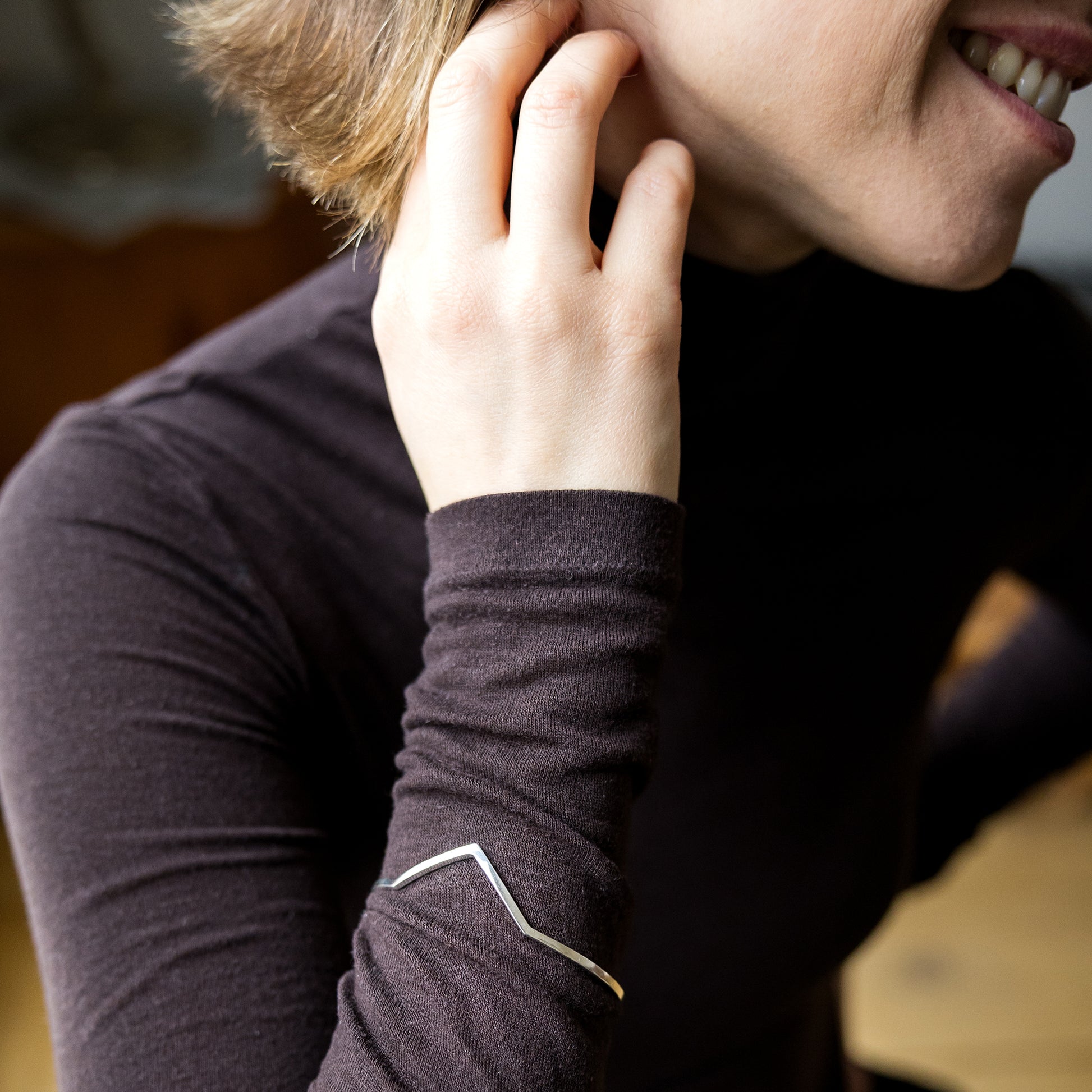 Person wearing a dark long-sleeve shirt with a visible brand logo.
