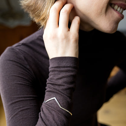 Person wearing a dark long-sleeve shirt with a visible brand logo.