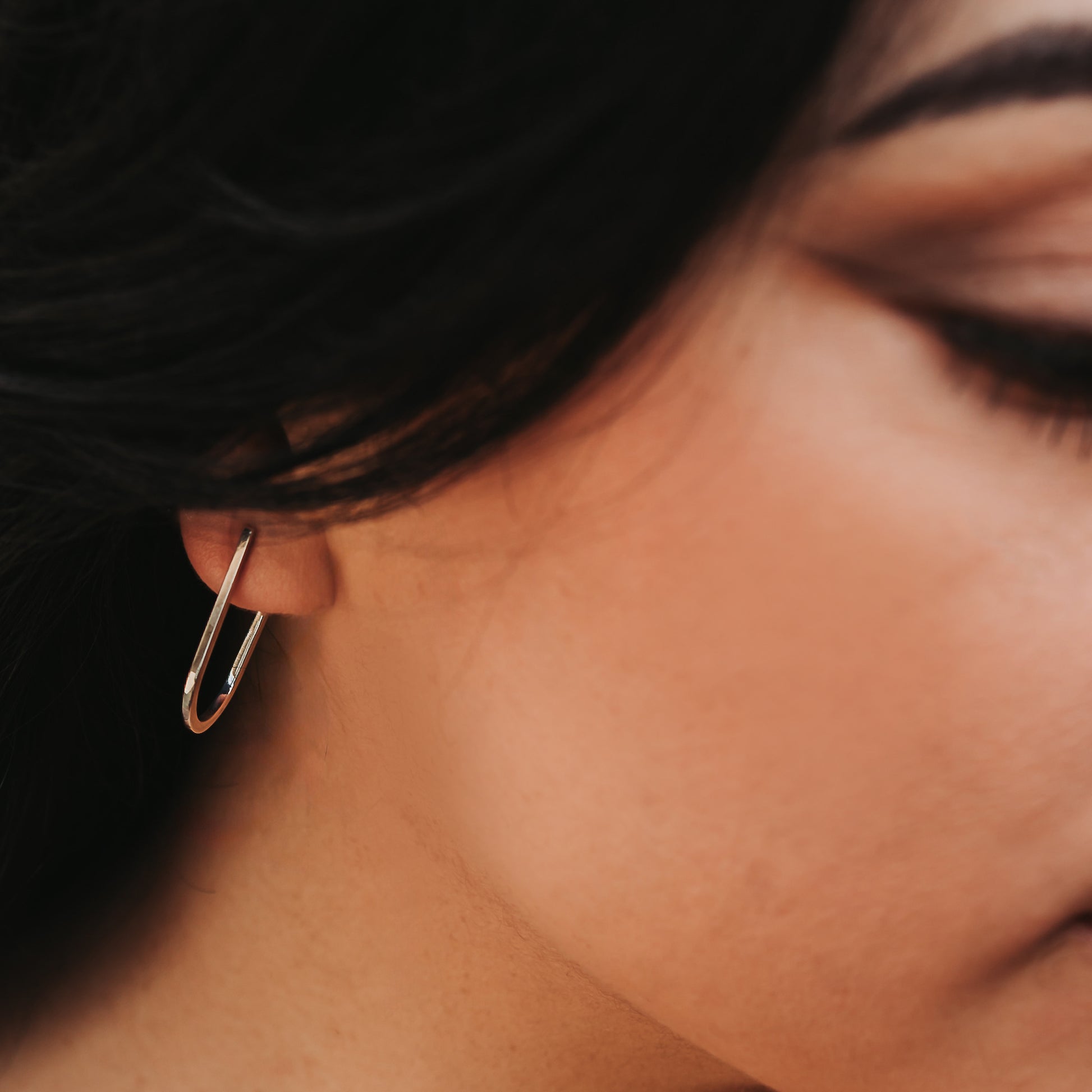 Close up of a person wearing silver hoop earrings