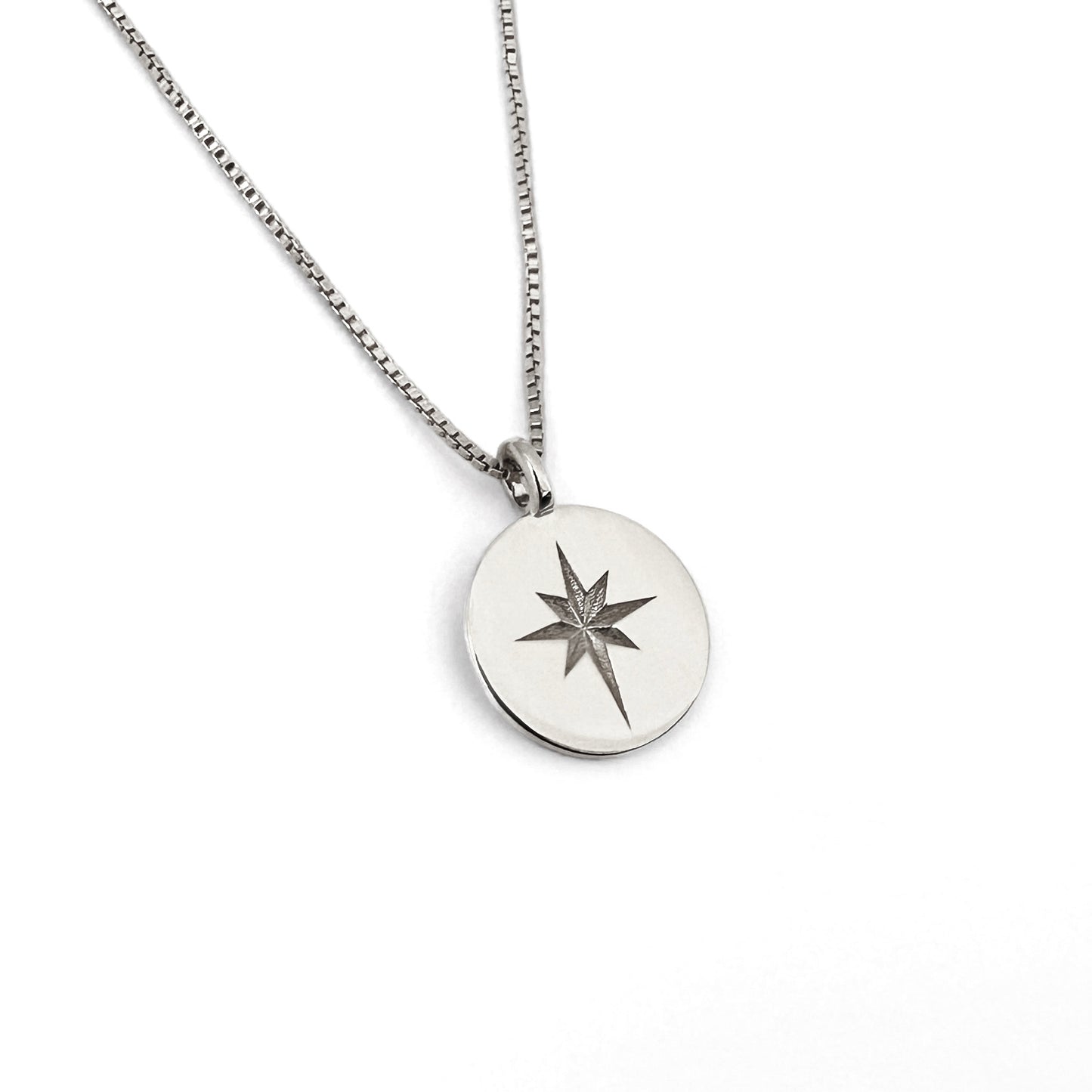 A silver coin necklace with a star design in the center, displayed on a box chain against a white background.