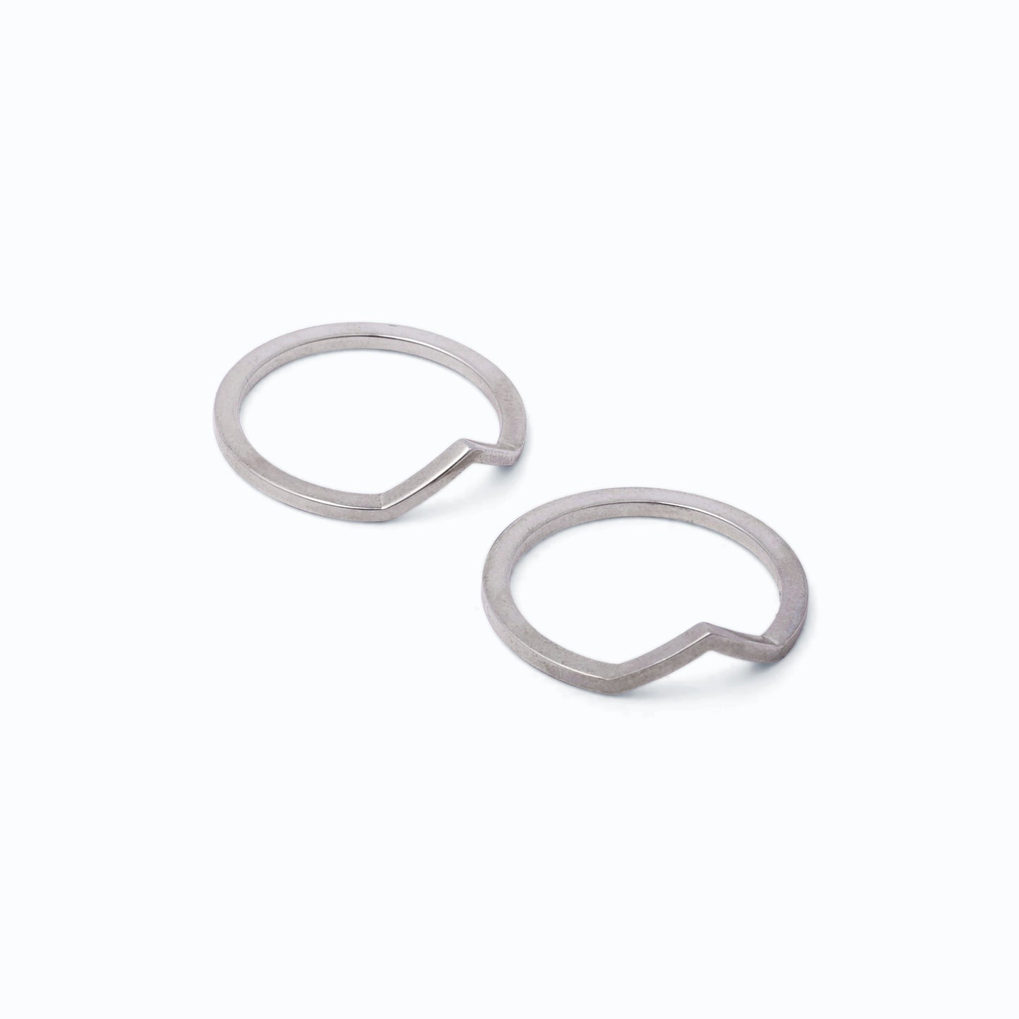 Pair of silver stacking rings with peak designs on a white background