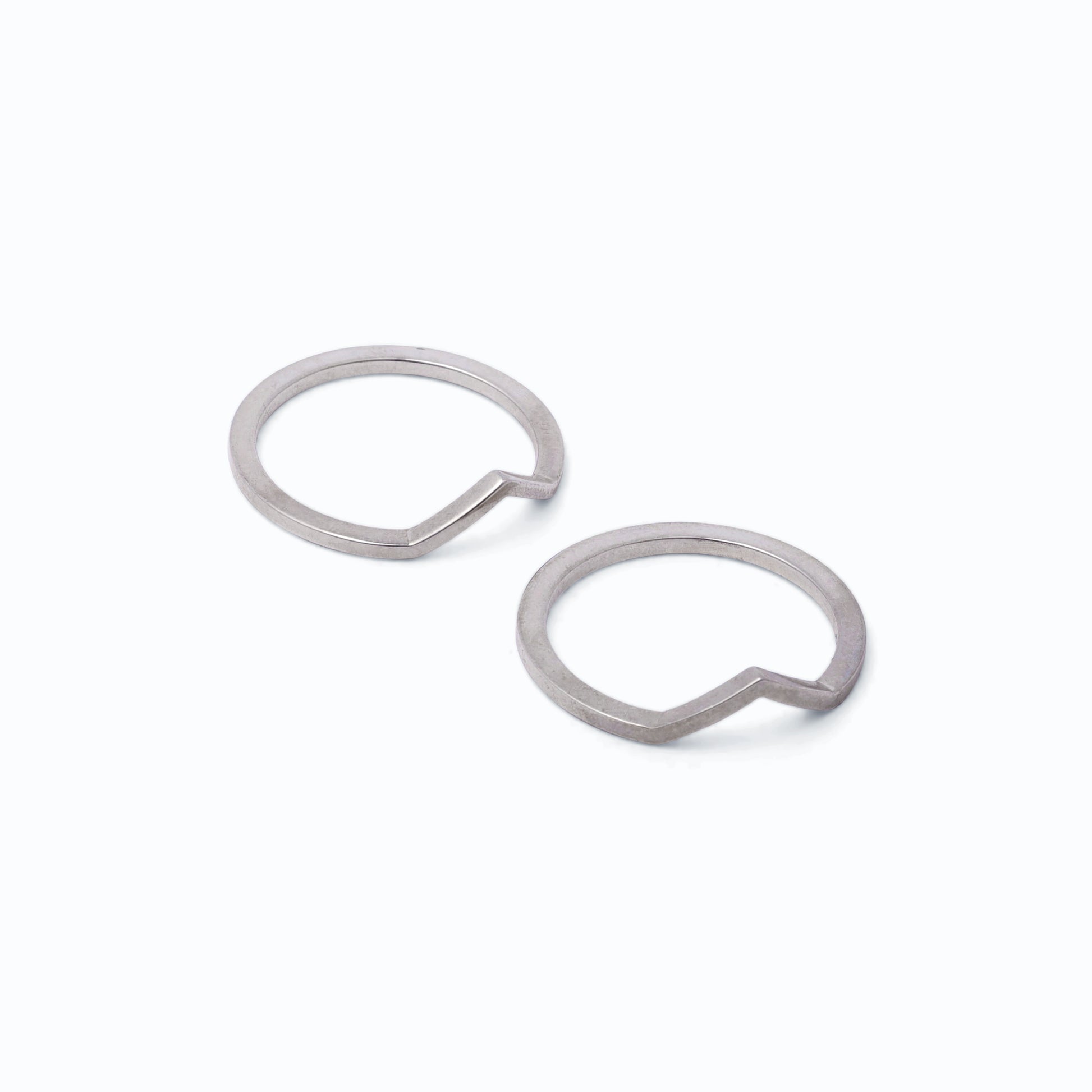 Pair of silver stacking rings with peak designs on a white background