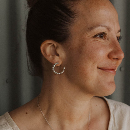 Silver Circular Dot Earrings on smiling woman