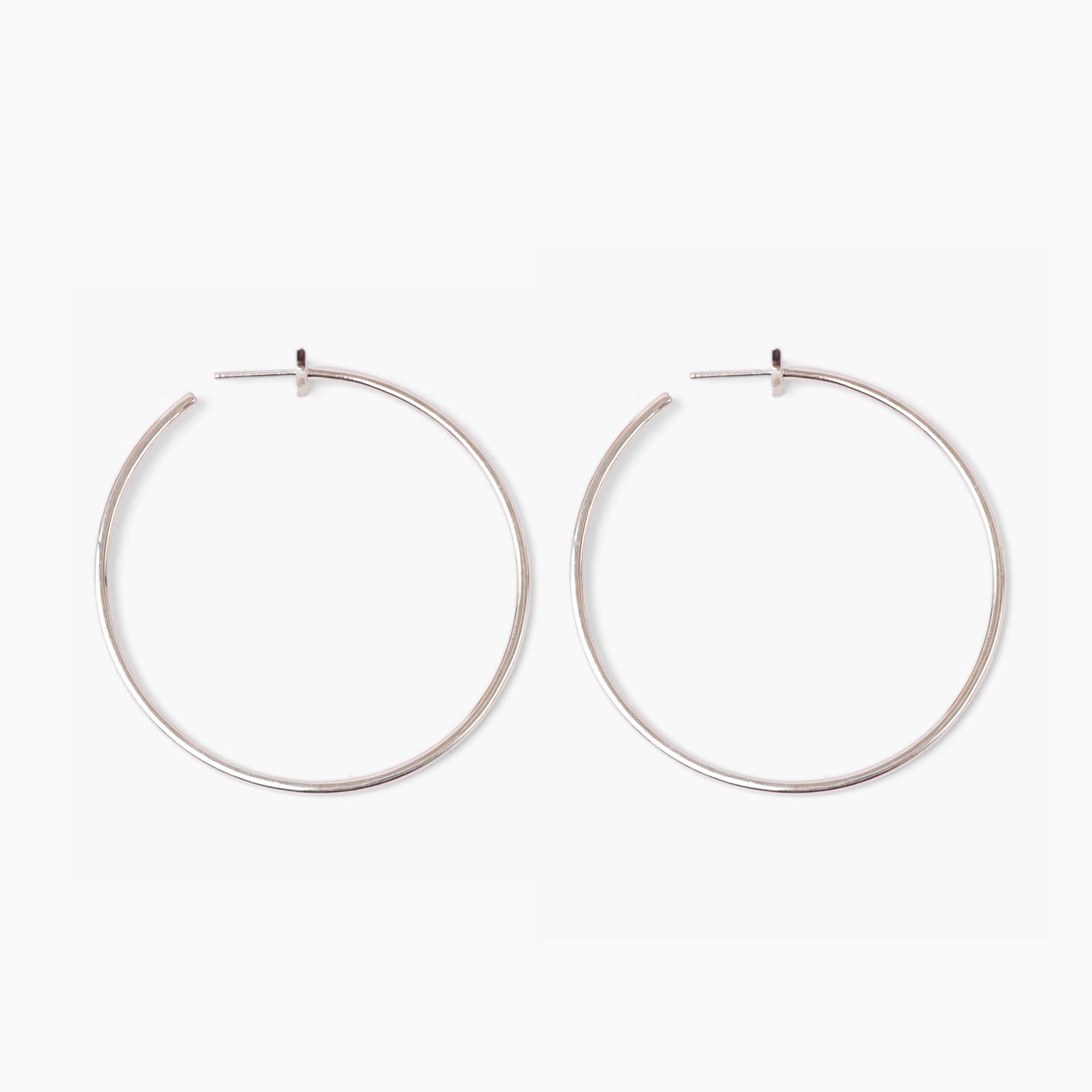 Pair of silver hoop earrings on a white background
