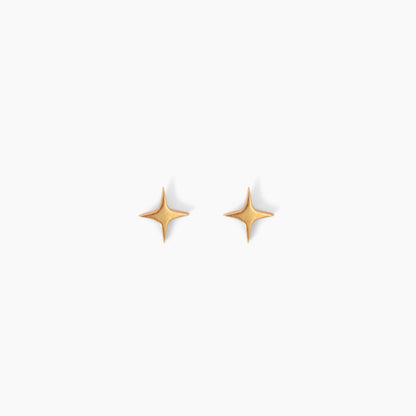 Pair of star shaped gold stud earrings on a white background