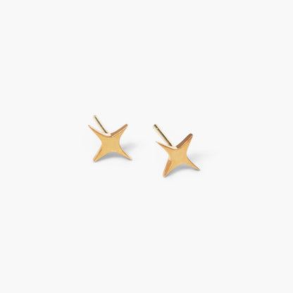 A pair of gold-colored star-shaped stud earrings against a white background.