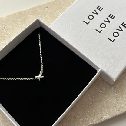 Silver necklace with a star pendant in a 'LOVE' branded box.