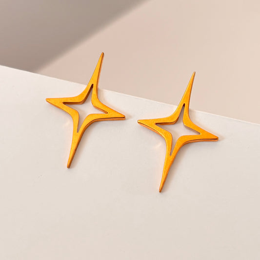 Large Gold Star Earrings on white background
