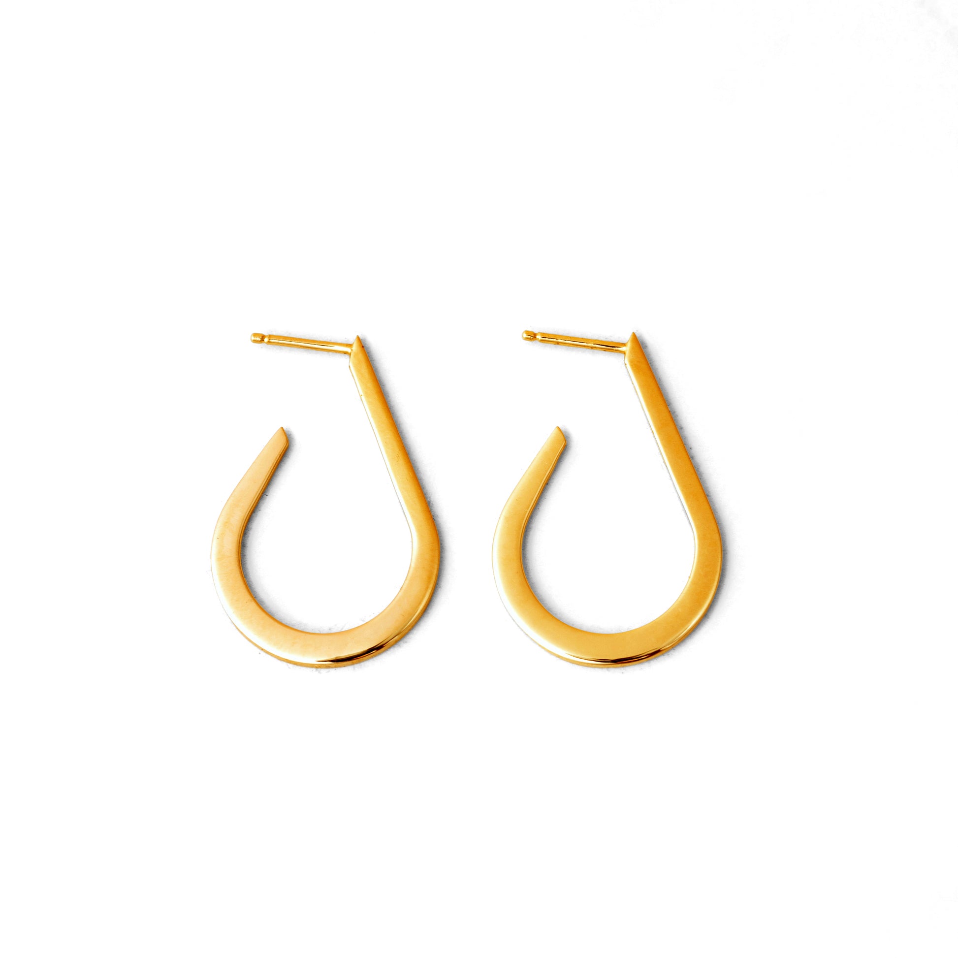 A pair of gold-colored curved droplet earrings on a white background.