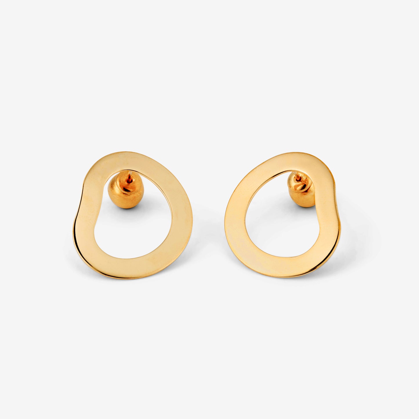 A pair of gold-colored geometric earrings with an open-oval shape accompanied by two small orb-style backings on a white background.