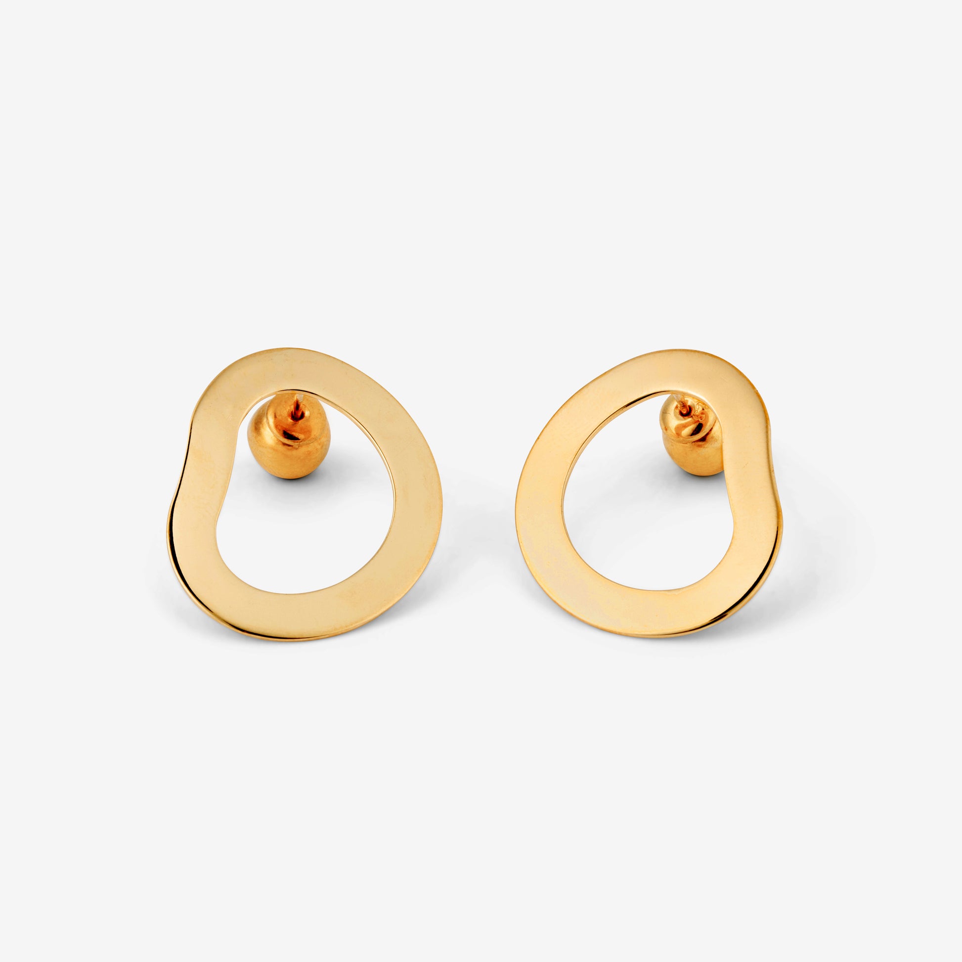 A pair of gold-colored geometric earrings with an open-oval shape accompanied by two small orb-style backings on a white background.