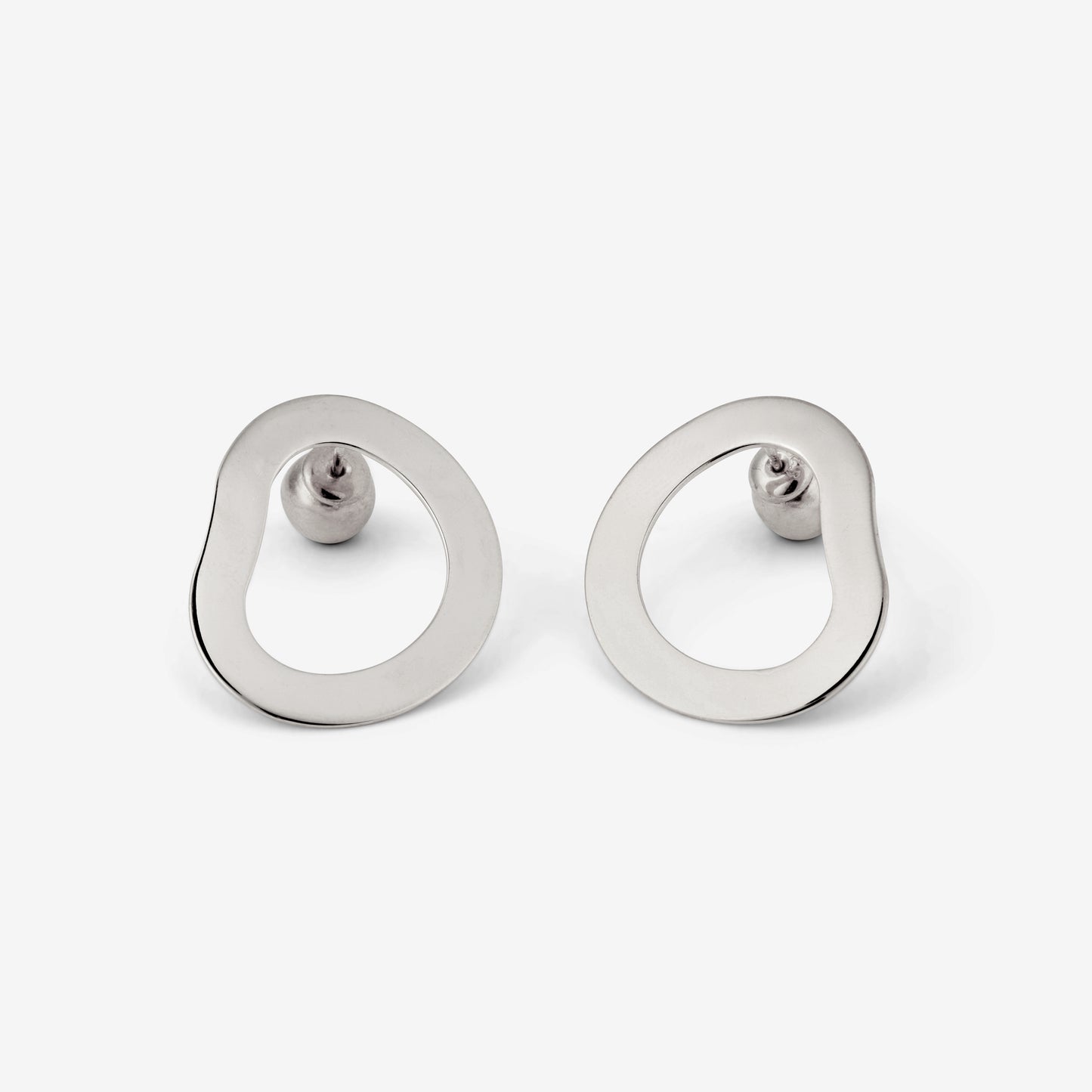 A pair of silver-colored geometric earrings with an open-oval shape accompanied by two small orb-style backings on a white background.