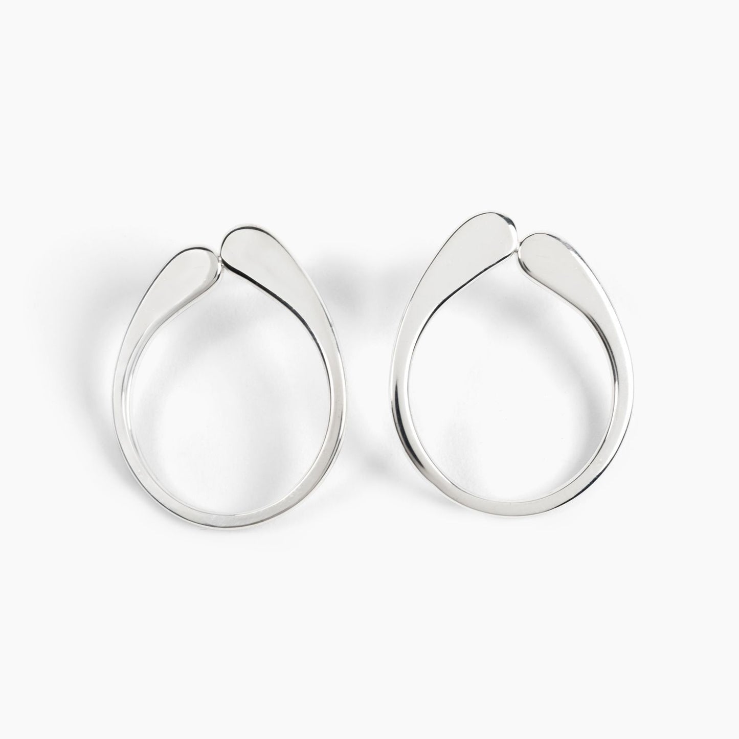 A pair of silver hoop earrings with a drip-like detail at the top, displayed against a white background.