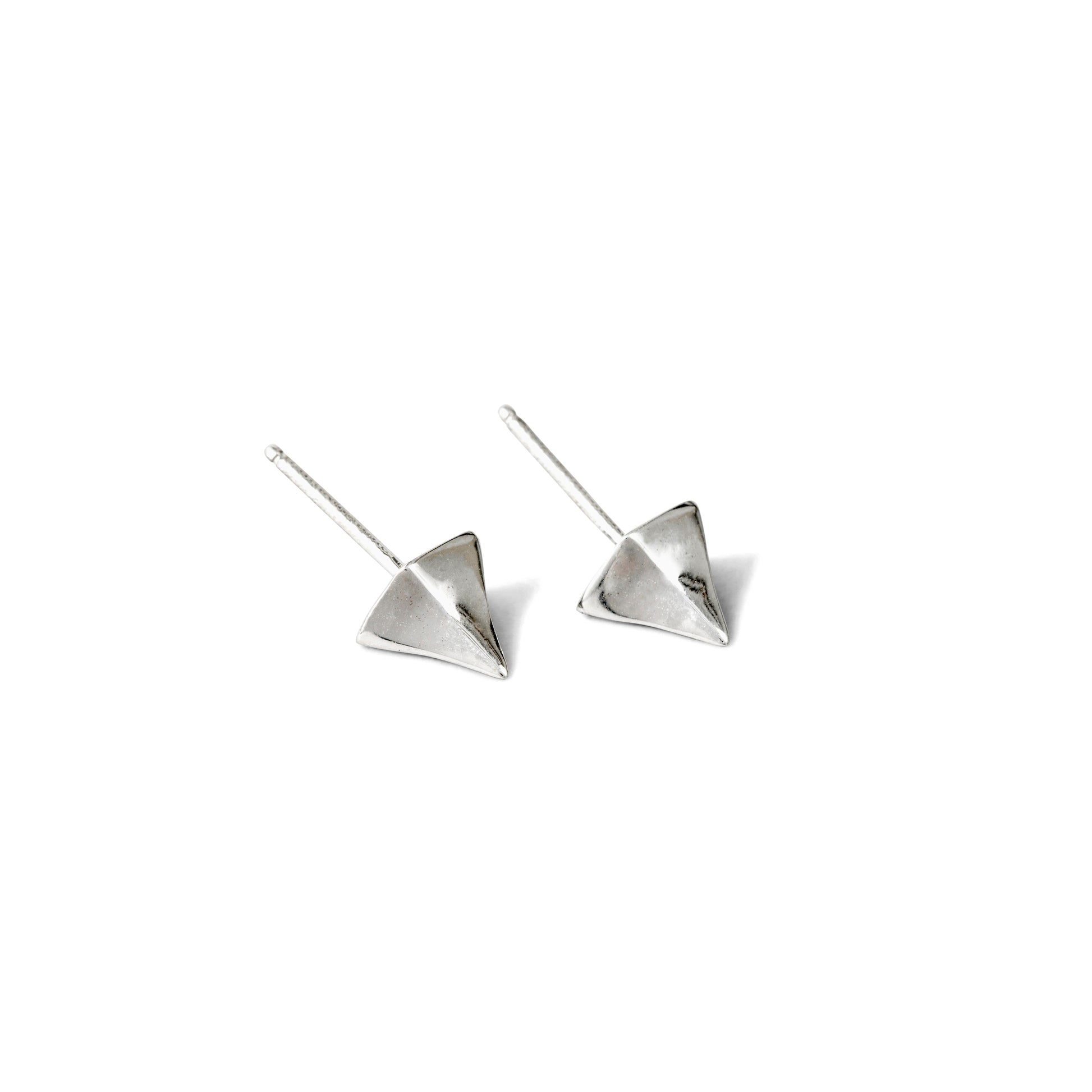 A pair of small, silver, pointed stud earrings against a white background.
