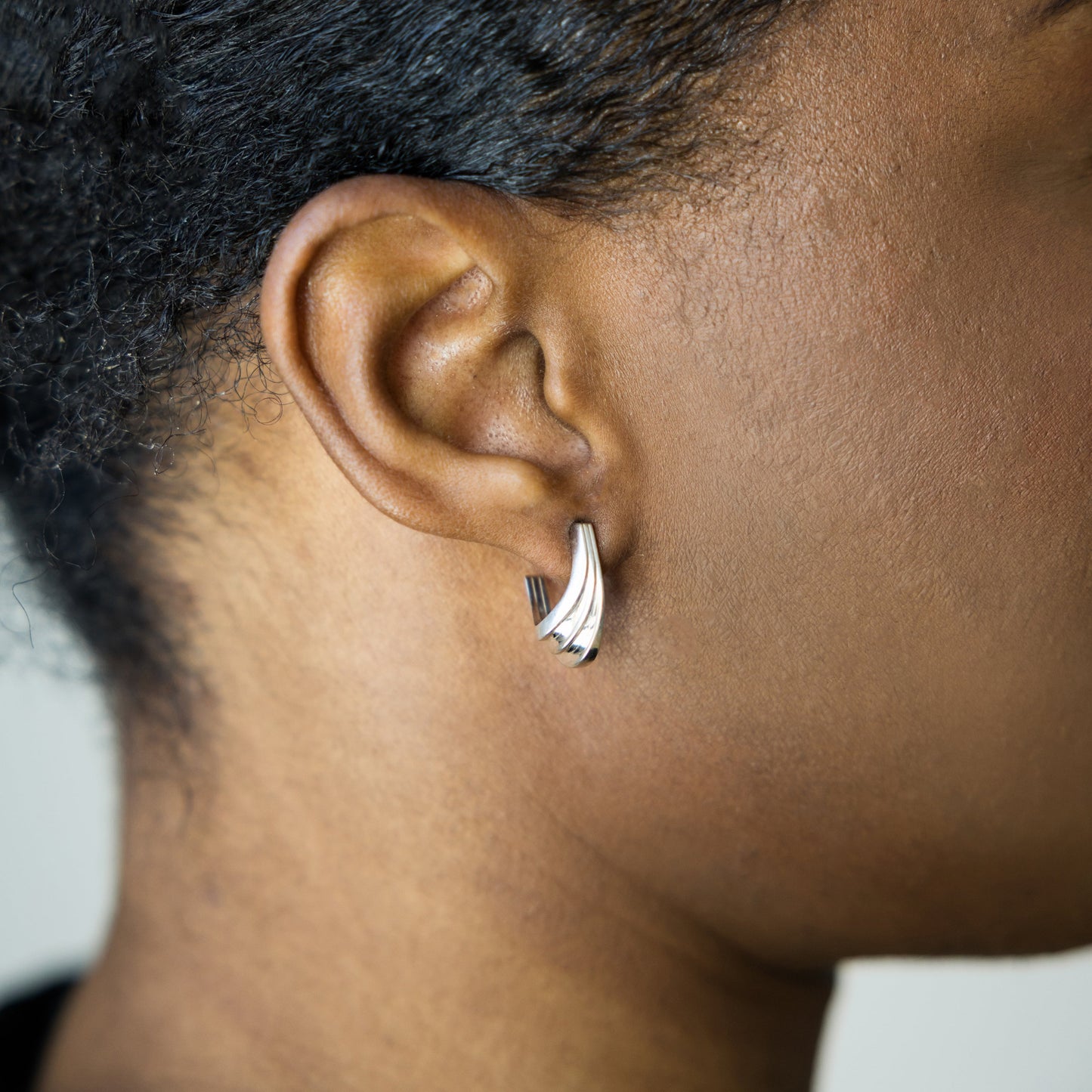 Close-up of an ear wearing a silver earring jewelry