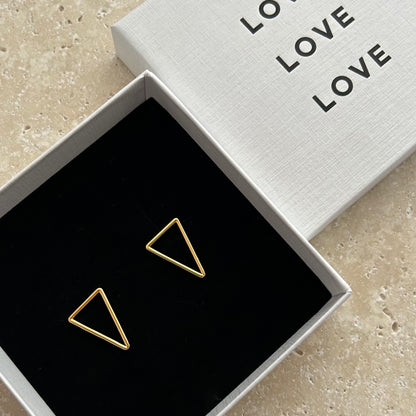 Gold triangle earrings in a box with 'LOVE' text on the lid.