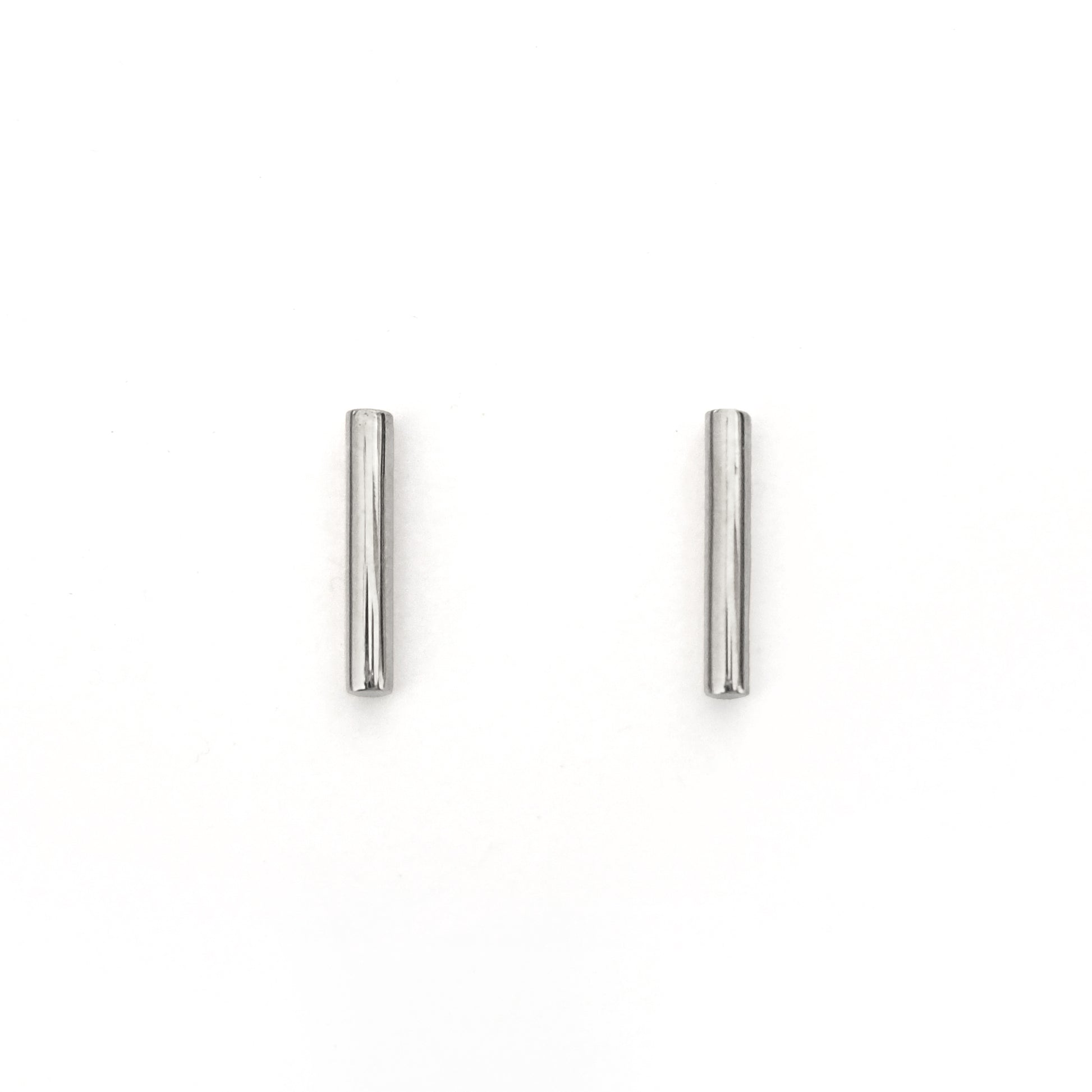 Pair of silver tubular earrings on a white background