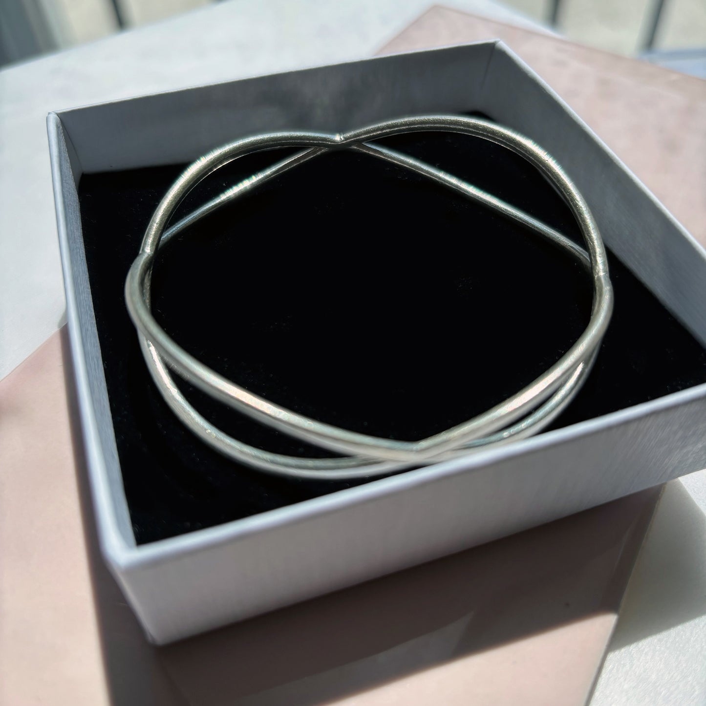 Silver bracelet in a black jewelry box on a light surface