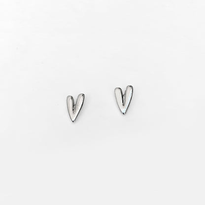 A pair of silver-colored stud earrings in the shape of elongated hearts.