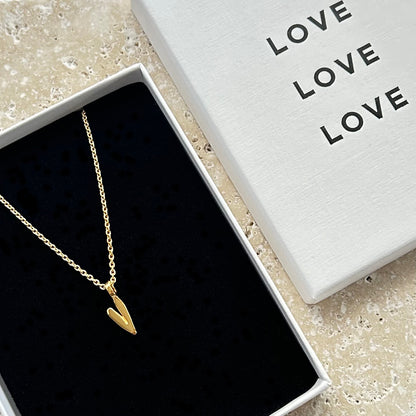 Gold necklace with a heart pendant in a box labeled 'LOVE'.