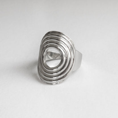 Silver ring with a textured design on a light gray background