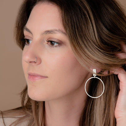 Person wearing silver hoop earrings.