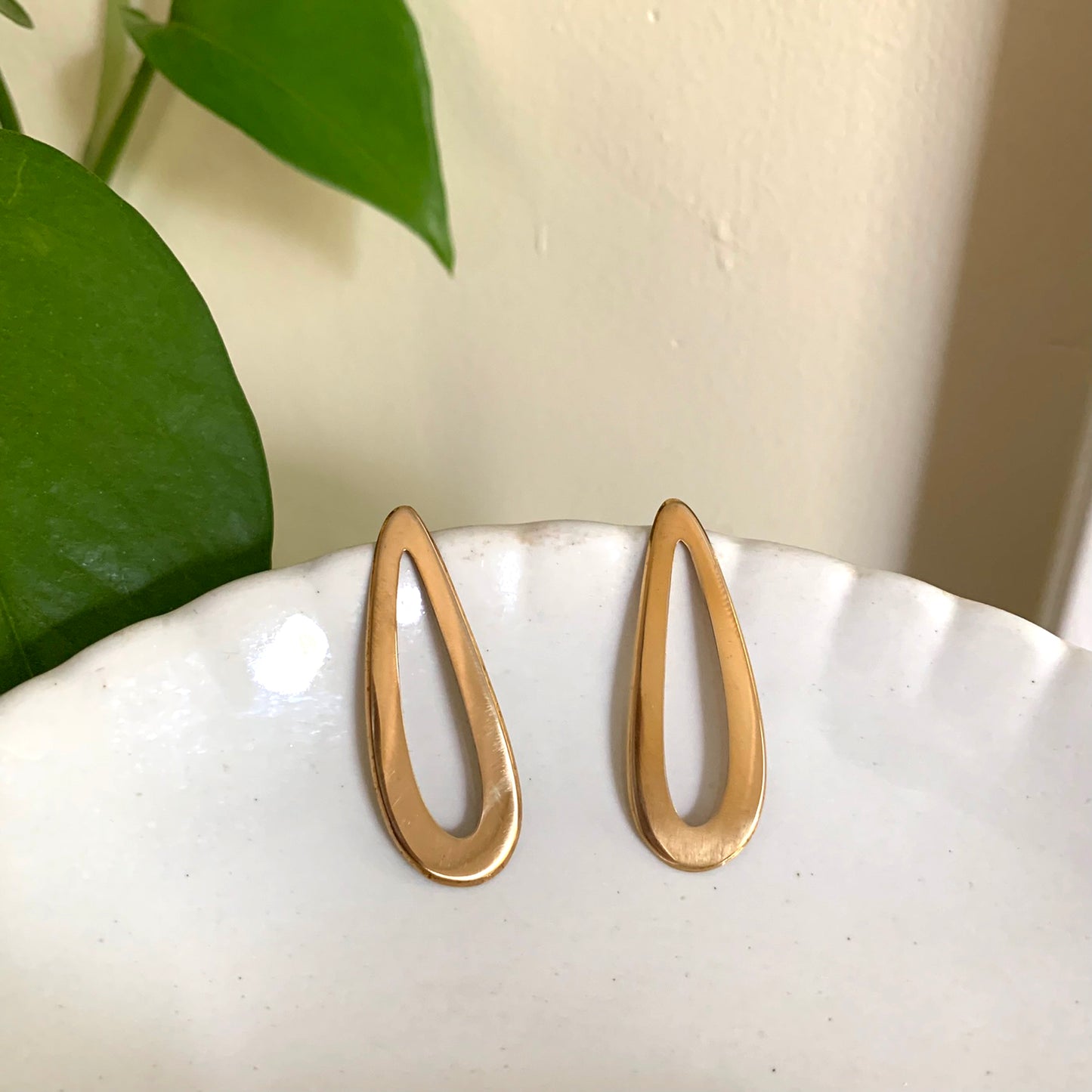 Pair of gold earrings on a white background.
