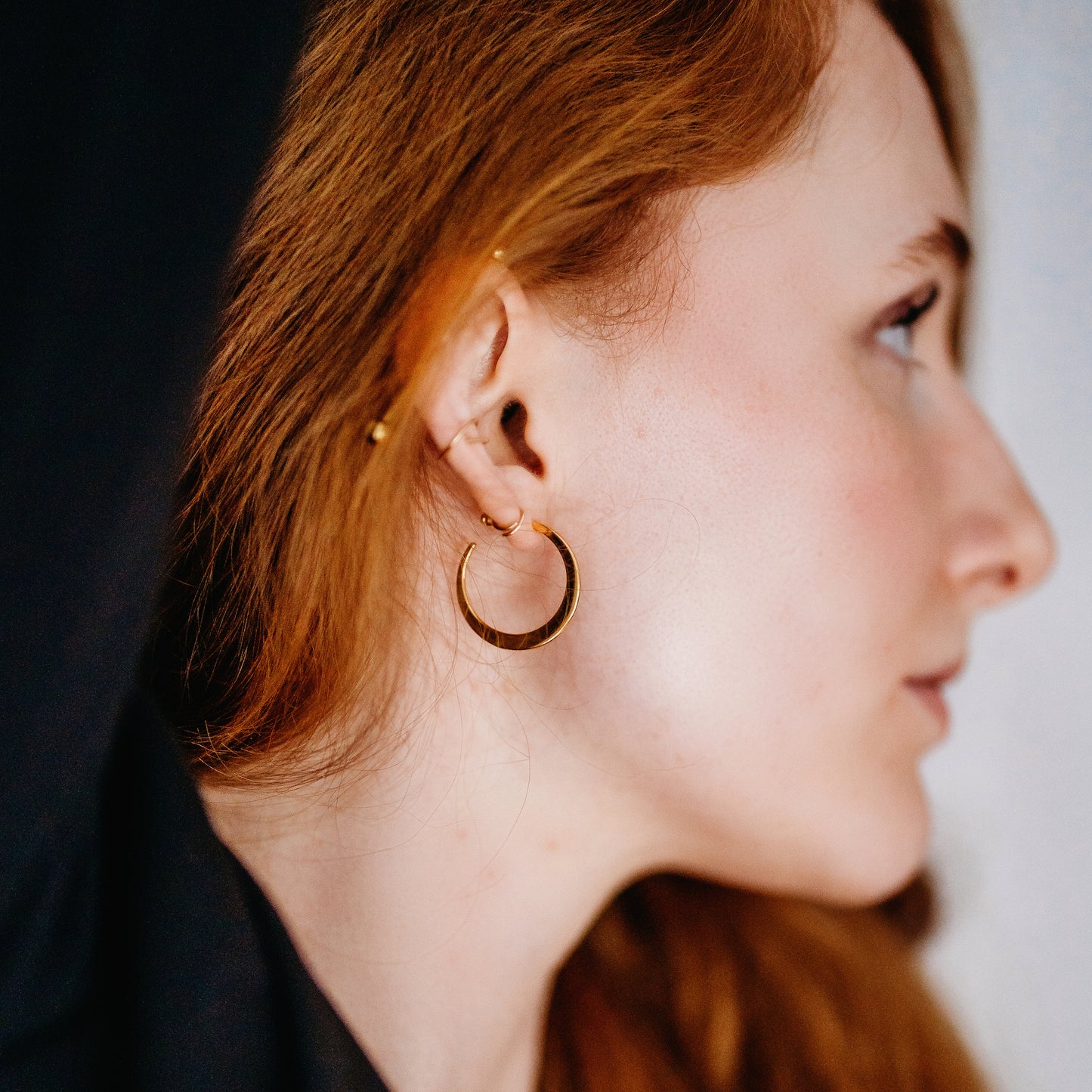Person wearing a gold hoop earring.