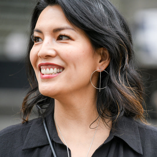Person wearing large circular silver earrings.