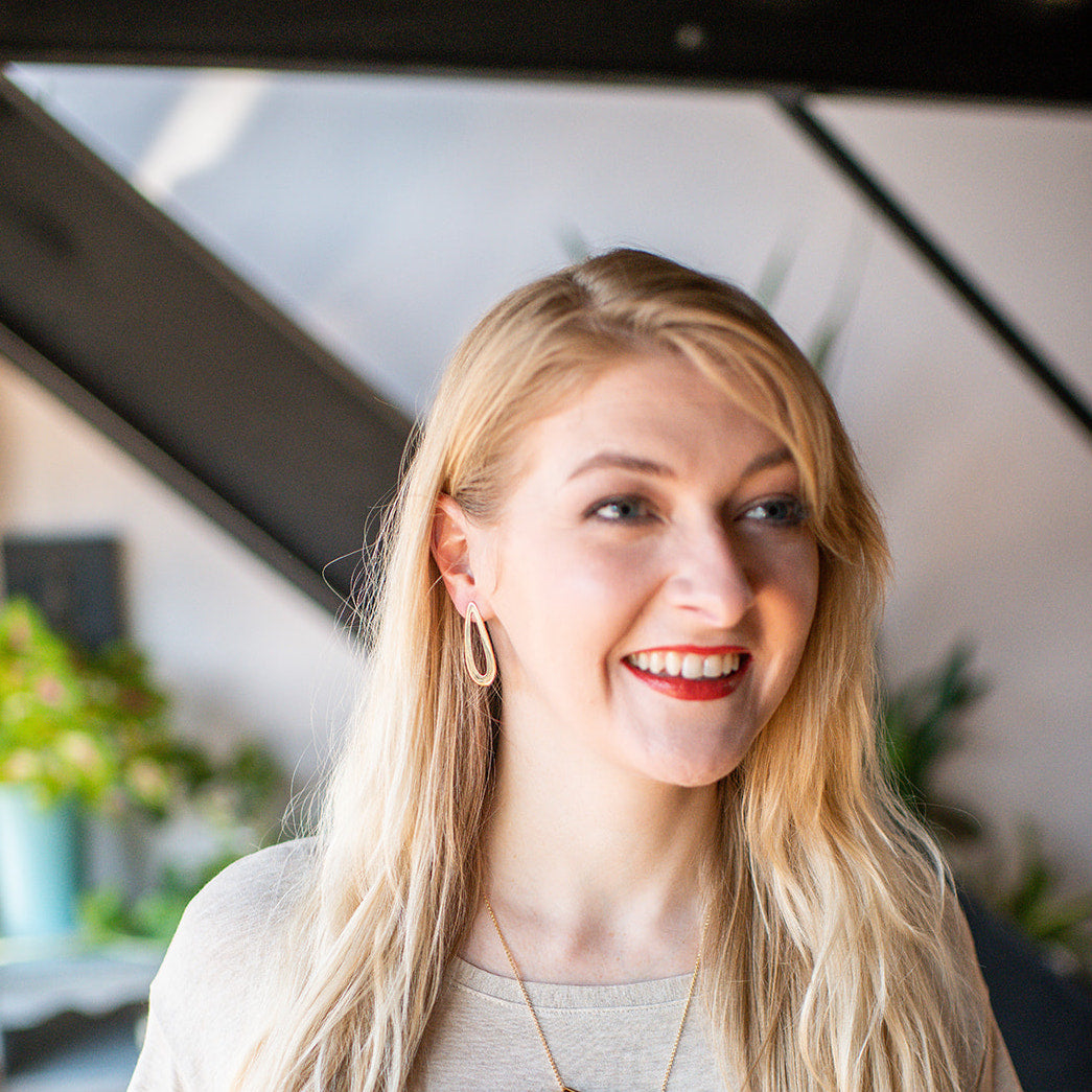 Person wearing gold swoop earrings.